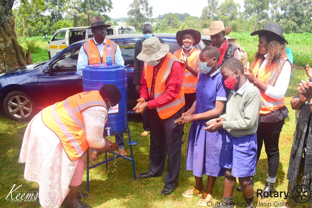 Rotarians and schoolchildren using a new handwashing station in Kapseret